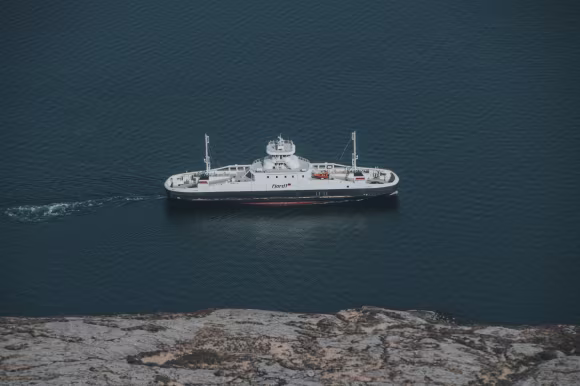 ferge som ferder på fjorden. fjord1 på siden. land ved siden av